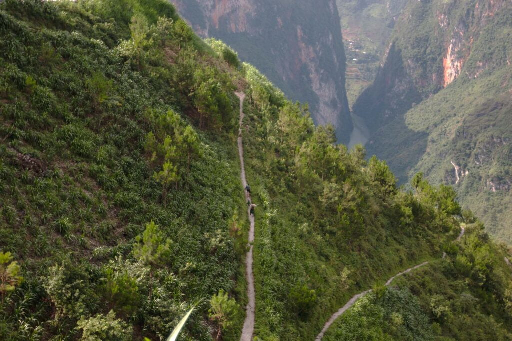 Photo show local People in Meo Vac walking on the slope. in the middle of Ma Pi Leng mountain